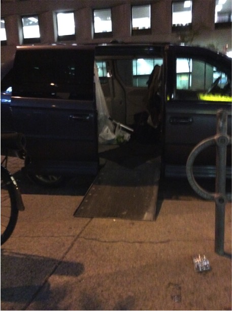 Accessibility ramp being lowered to demonstrate appropriate space needed in between vans in parking spaces.